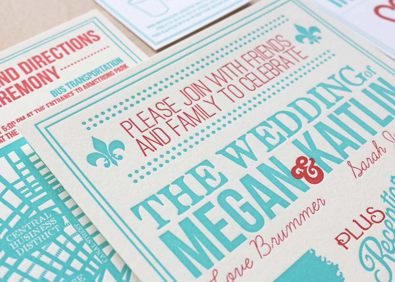 Layered letterpress-printed wedding pieces in teal and red ink on cream cotton paper, showing deep impression and two-color printing