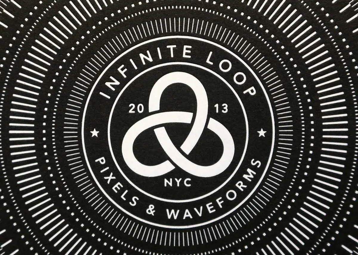 Spread of Infinite Loop business cards on dark surface showing both sides of the card